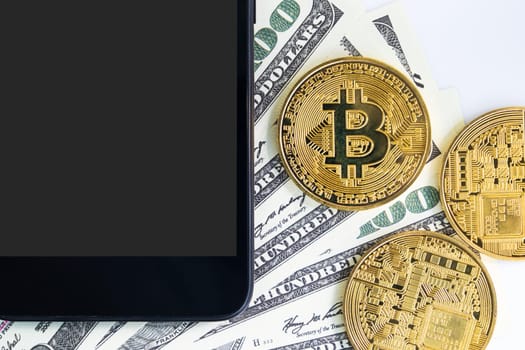 Top view Bitcoins coin and  US banknotes of one hundred dollars with smartphone. Close up of metal shiny bitcoin crypto currency coins and US dollar