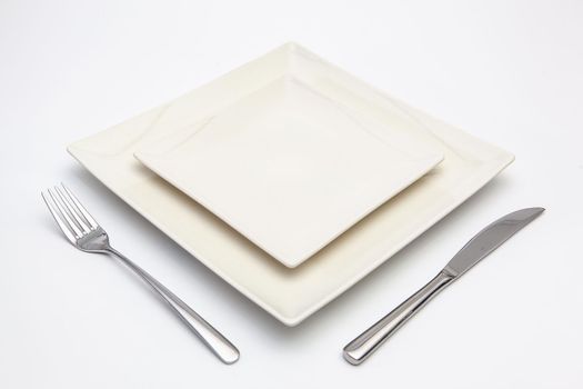 White square plate on the white wooden table.Top view.Flat Lay Image.