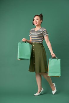 attractive happy smiling stylish woman holding colorful shopping bags