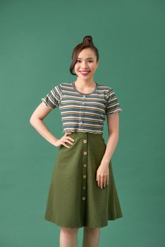 Casually dressed young woman over green background