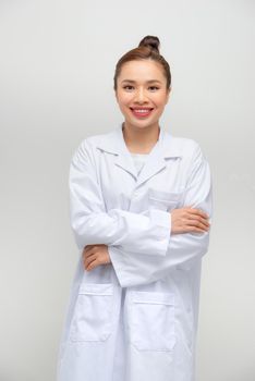 Young smiling female doctor standing isolated on white