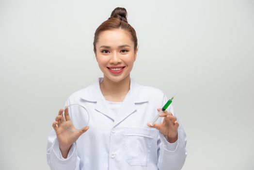 Female scientist testing experiment in a science lab where she looking to bacteria germs in agar plate.