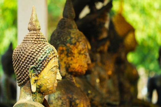 close up to ancient buddha head many style have rust and erosion on skin texture on outdoor