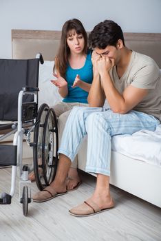 Desperate man on wheelchair with his sad wife