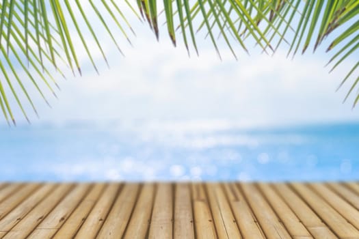 Selective focus of old wood table with blur beautiful beach for display your product.