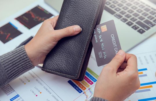 Businesswoman hands holding leather wallet with credit cards on office desk. Business, finances and money concept.