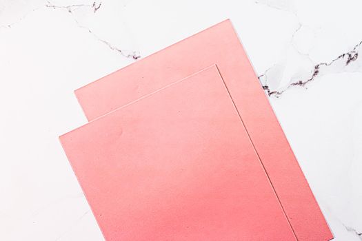 Pink A4 papers on white marble background as office stationery flatlay, luxury branding flat lay and brand identity design for mockups