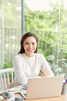 Happy young Asian girl relax sitting on desk do job in internet.