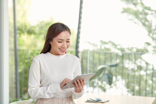 Beautiful asian woman using tablet in bright room