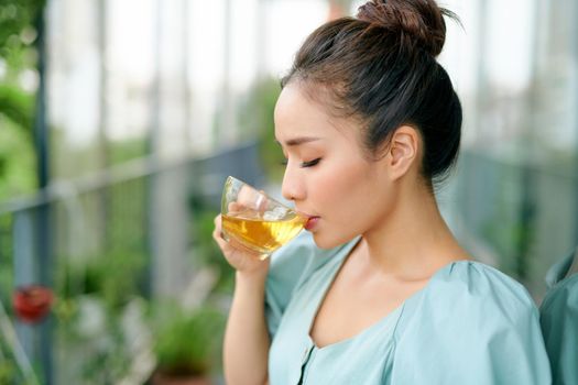 portrait of young woman on the balcony holding a cup of tea in the morning.