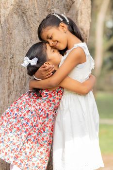 Tender little sisters hugging each other and showing their true love