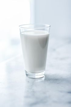 Dairy, healthy nutrition and breakfast concept - World Milk Day, full glass on marble table