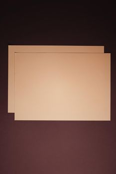 Blank A4 paper, beige on dark background as office stationery flatlay, luxury branding flat lay and brand identity design for mockups