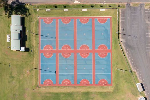 Drone aerial photograph of colourful netball courts and large sports fields in regional New South Wales in Australia