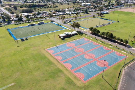 Drone aerial photograph of colourful netball courts and large sports fields in regional New South Wales in Australia