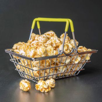 steel supermarket basket with popcorn on a black background close-up. High quality photo