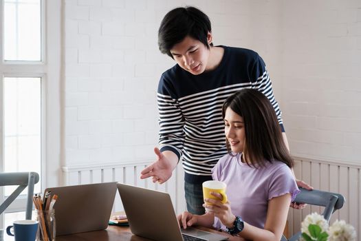 Young university man help friend tutorial math, physics before exam in living room by online class in laptop computer