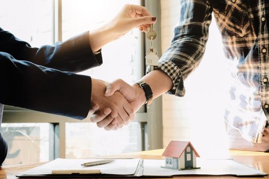 Real estate agent and customers shaking hands together celebrating finished contract after about home insurance and investment loan, handshake and successful deal.