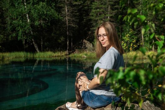 Woman resting at mountain lake in summer, Altai mountains