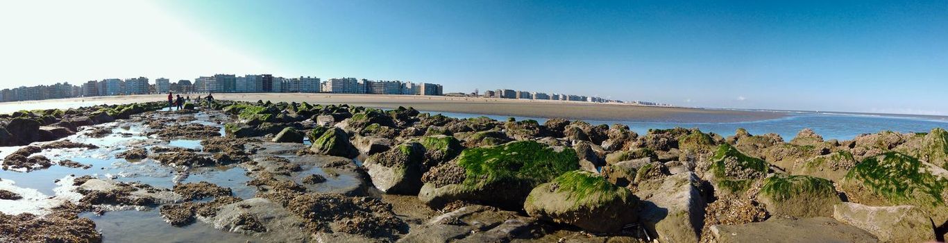 Panoramic View from breakwater in Sint-Idesbald in Koksijde to the sand and the appartements on a sunny day in spring.