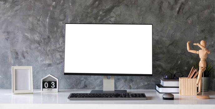 Creative designer desktop with blank white laptop screen with mockup poster on white desk.