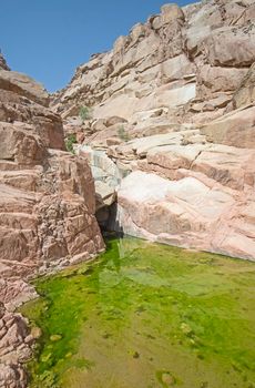 Freshwater pool under overhang in desert mountain canyon
