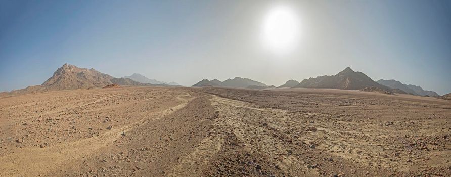 Landscape scenic view of desolate barren rocky eastern desert in Egypt with mountains and sunlight