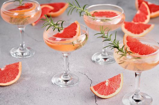 Goblet of sparkling wine with a slice of grapefruit and a sprig of rosemary