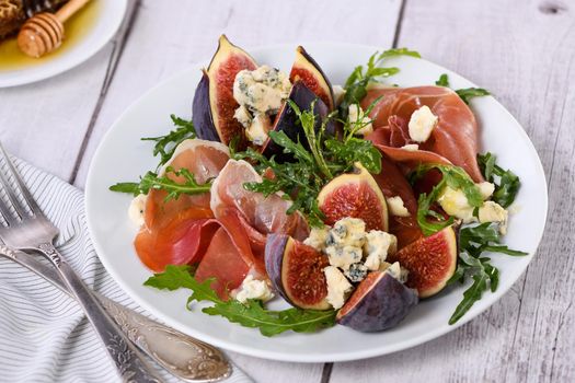 Appetizer arugula with Parma ham and fresh figs stuffed blue cheese, honey