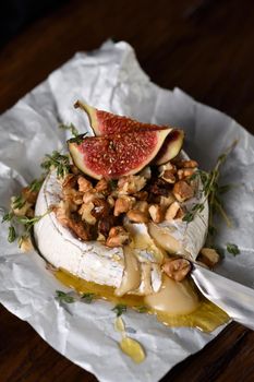 Baked camembert with nuts and honey, fig and thyme slices.