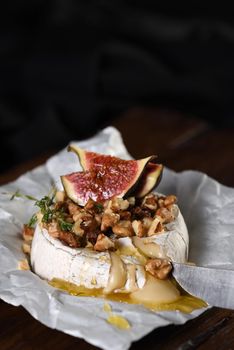 Baked camembert with nuts and honey, fig and thyme slices.