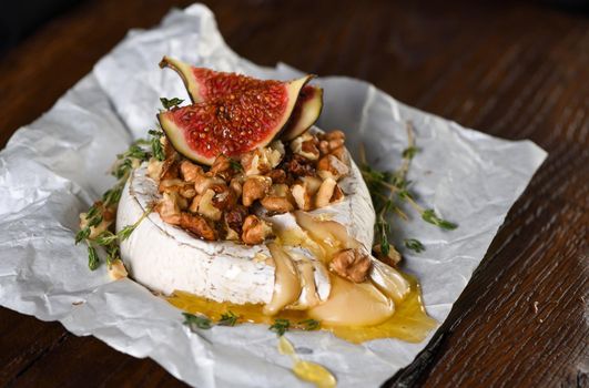 Baked camembert with nuts and honey, fig and thyme slices.