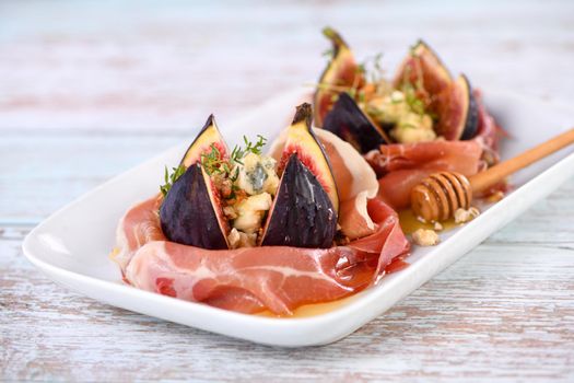 Figs stuffed with blue cheese, wrapped in Parma ham, drizzled with honey