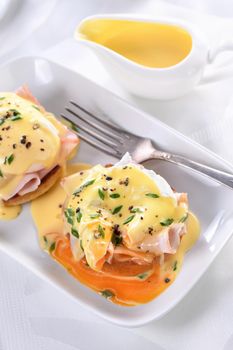 Breakfast. Best Eggs Benedict - fried English bun, ham, poached eggs and delicious Hollandaise   butter sauce