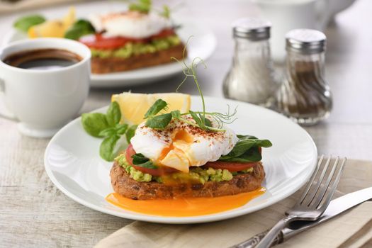  Breakfast. Best Eggs Benedict on a slice of toasted cereal bread with guacamole and spinach