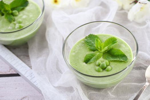 Chilled green pea puree soup with tender milk cream and refreshing mint