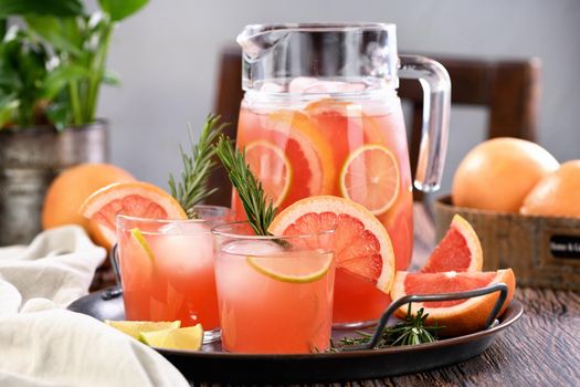 Fresh grapefruit cocktail. Fresh summer cocktail with grapefruit, lime, sprig of rosemary and ice cubes.