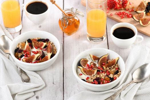 Healthy and delicious breakfast. Oatmeal muesli with Greek yogurt, fresh figs, dried fruits and pomegranate.