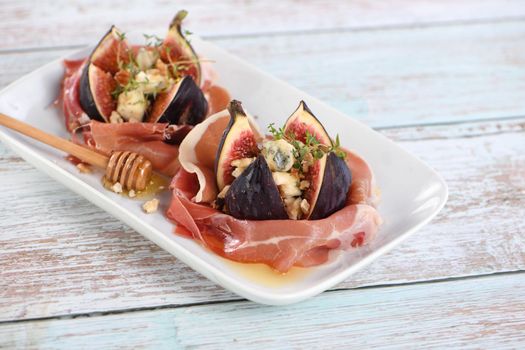 Figs stuffed with blue cheese, wrapped in Parma ham, drizzled with honey