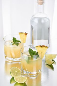 Cocktail  silver tequila with pineapple juice, lime slice, cooled with ice and mint