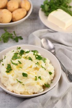 A plate of mashed potatoes poured with melted butter and seasoned with greens