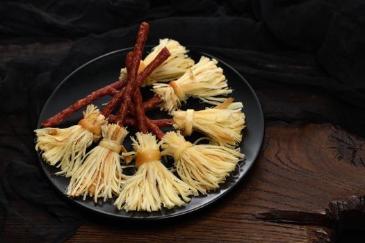 Witches Broom of smoked cheese suluguni and salami. Original idea Halloween snack.