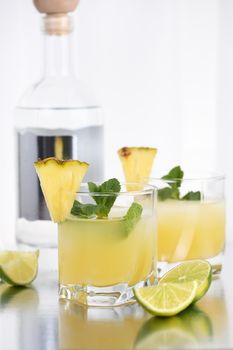 Vodka cocktail with pineapple juice, a slice of lime, cooled with ice and mint