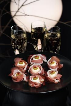 Original Halloween snacks. Eyeballs cooked from ham with mozzarella, olives stuffed with red pepper