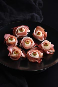 Original Halloween snacks. Eyeballs cooked from ham with mozzarella, olives stuffed with red pepper