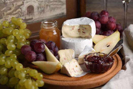 Antipasti.    Cheese camembert with grapes, sliced pears and confiture, a great appetizer for wine.