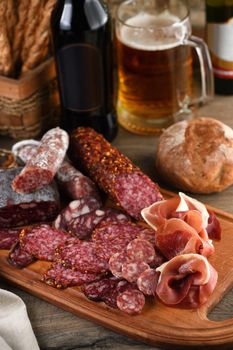 Antipasti dish with bacon, jerky, salami, crispy grissini with cheese. A meat appetizer is a great idea for a beer.