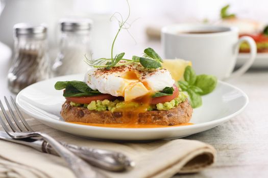  Breakfast. Best Eggs Benedict on a slice of toasted cereal bread with guacamole and spinach