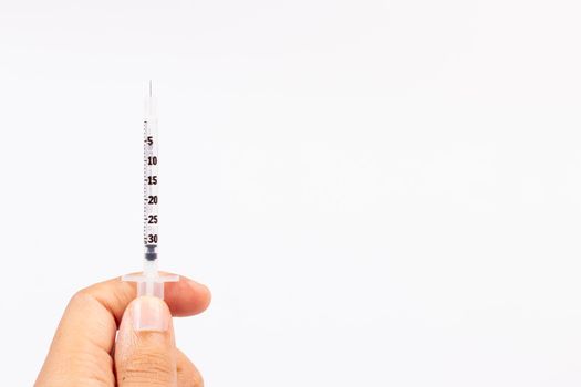 Hand holding an insulin syringe before being used