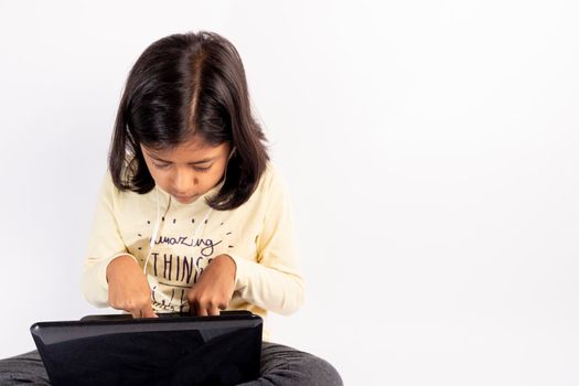 Cute little girl is using her notebook and headphones